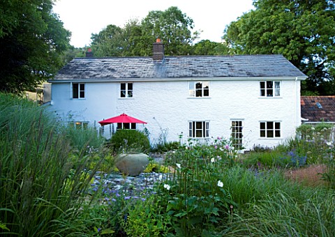 CLARE_MATTHEWS_HOUSE__DEVON_VIEW_TO_HOUSE_WITH_PERENNIAL_PLANTING_IN_FOREGROUND_DESIGNER_CLARE_MATTH