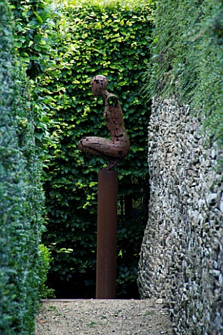 THROUGHAM_COURT__GLOUCESTERSHIRE_DESIGNER_CHRISTINE_FACER_RED_WALK_WITH_CROUCHING_WOMAN_SCULPTURE_BY