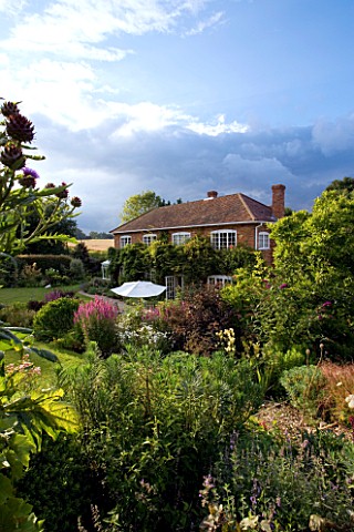 MARINERS_GARDEN__BERKSHIRE_DESIGNER_FENJA_ANDERSON__THE_HOUSE_FROM_THE_UPPER_GARDEN_WITH_STORMY_SKY_
