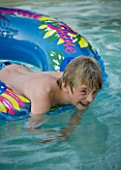 BOY (AGED 13) ENJOYING HIMSELF IN A SWIMMING POOL. FUN  WATER