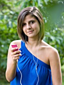TEENAGE GIRL (16-17 YEARS) IN BLUE TOP SITTING LISTENING TO MP3 PLAYER. MUSIC  TEENAGE GIRLS  ONE TEENAGE GIRL ONLY  CASUAL CLOTHING  STUDENT  COLLEGE  MUSIC