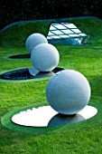 THROUGHAM COURT  GLOUCESTERSHIRE. DESIGNER: CHRISTINE FACER: THE GARDEN OF COSMIC SPECULATION. COSMIC ANCASTER STONE SPHERES & OVAL MIRROR POLISHED STAINLESS STEEL BASE. REFLECTION
