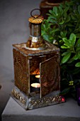 DESIGNER - CHARLOTTE ROWE  LONDON: CHARLOTTE ROWES OWN GARDEN AT NIGHT -  ORNATE MOROCCAN CANDLE HOLDER WITH CANDLE INSIDE