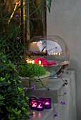 DESIGNER - CHARLOTTE ROWE  LONDON: CHARLOTTE ROWES OWN GARDEN AT NIGHT - RENDERED RAISED BED WITH CANDLES  RESIN PLANTER WITH SOLEIROLIA SOLEIROLII  GLASS BOWL