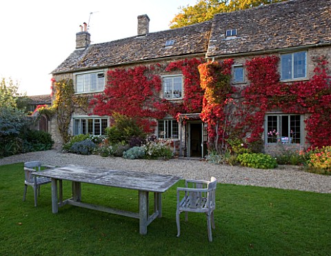 THE_GRAY_HOUSE__OXFORDSHIRE__DESIGNED_BY_TIM_REES_BACK_OF_THE_GRAY_HOUSE_IN_AUTUMN_WITH_WOODEN_TABLE