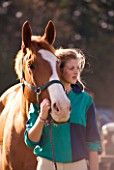 GIRL (AGED 15) AT HORSE JUMPING COMPETITION WITH HORSE