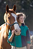 GIRL (AGED 15) AT HORSE JUMPING COMPETITION WITH HORSE