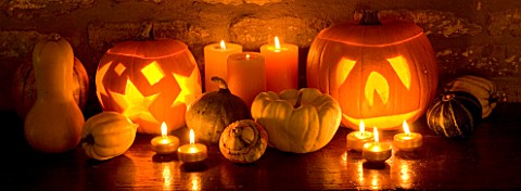 HALLOWEEN_STILL_LIFE_ON_SIDEBOARD_AT_NIGHT_WITH_ORANGE_CANDLES__PUMPKINS__SQUASHES_AND_GOURDS