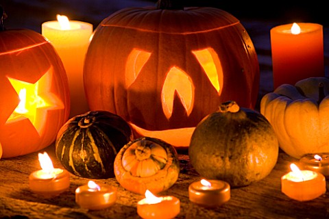 HALLOWEEN_STILL_LIFE_ON_WOODEN_TABLE_AT_NIGHT_WITH_CANDLES__PUMPKINS__GOURDS_AND_SQUASHES