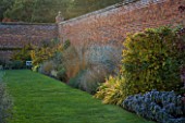 MARKS HALL  ESSEX : HERBACEOUS BORDER IN AUTUMN BESIDE THE WALL IN THE WALLED GARDEN
