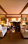 BOONSHILL FARM AT CHRISTMAS: THE LIVING ROOM WITH SETTEES  FIREPLACE AND GLASS COFFEE TABLE WITH INDIAN DECORATIVE GLASSES. DESIGNER: LISETTE PLEASANCE