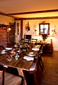 BOONSHILL FARM AT CHRISTMAS: THE DINING ROOM LAID OUT FOR CHRISTMAS WITH CRACKERS  MISTLETOE IN SILVER CONTAINER AND MIRROR BEHIND. DESIGNER: LISETTE PLEASANCE