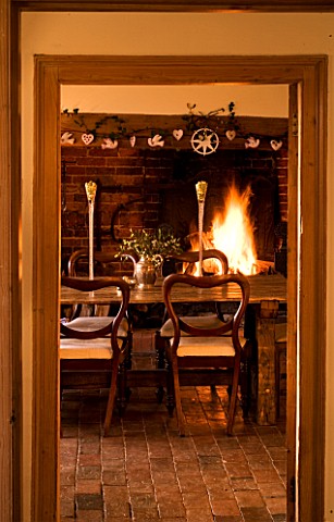 BOONSHILL_FARM_AT_CHRISTMAS_THE_DINING_ROOM__TABLE_WITH_CHAIRS_AND_FIRE_IN_BACKGROUND_DESIGNER_LISET