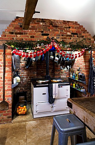 BOONSHILL_FARM_AT_CHRISTMAS_THE_KITCHEN_WITH_TABLE_AND_CHAIRS__AGA_AND_DECORATIONS_DESIGNER_LISETTE_