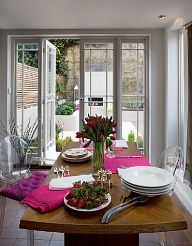 DESIGNER_CHARLOTTE_ROWE__LONDON_THE_DINING_ROOM_WITH_TABLE_WITH_RED_TULIPS_IN_A_GLASS_VASE__PINK_NAP