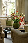 DESIGNERS SUE AYLETT: SUE AYLETTS HOUSE  LONDON: THE LIVING ROOM WITH BEAUTIFUL DISPLAY OF FLOWERS - CALLA LILIES  RANUNCULUS  TULIPS AND KANGAROO PAW IN GREEN CONTAINER