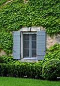 PRIVATE GARDEN  PROVENCE  FRANCE - DESIGNER DOMINIQUE LAFOURCADE. FRONT OF HOUSE WITH DETAIL OF WINDOW AND PAINTED SHUTTERS