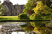 WAKEHURST PLACE  WEST SUSSEX. THE LAKE WITH THE HOUSE IN BACKGROUND