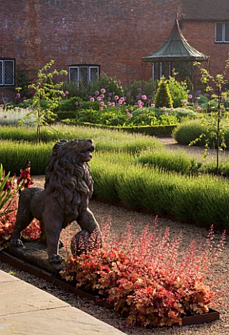 THE_WALLED_GARDEN_AT_COWDRAY__WEST_SUSSEX_DESIGNER_JAN_HOWARD__LION_STATUE_IN_EARLY_SUMMER_BORDER_WI