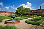 THE WALLED GARDEN AT COWDRAY  WEST SUSSEX. DESIGNER: JAN HOWARD - GRAVEL GARDEN WITH RAISED BRICK POOL/POND WITH FOUNTAIN AND LAVENDER EDGED BEDS