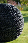 DAVID HARBER SUNDIALS: CLOSE UP OF RIVER POLISHED PEBBLES OF THE KERNAL SCULPTURE ON LAWN AT PETTIFERS GARDEN  OXFORDSHIRE