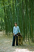 LA BAMBOUSERAIE DE PRAFRANCE  FRANCE: OWNER MURIEL NEGRE WITH HER DOG IN THE BAMBOO FOREST