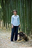 LA BAMBOUSERAIE DE PRAFRANCE  FRANCE: OWNER MURIEL NEGRE WITH HER DOG IN THE BAMBOO FOREST