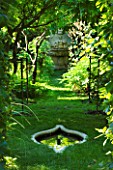 CHATEAU PLAISIR  FRANCE  DESIGNER: PASCAL CRIBIER. SECRET WISTERIA WALK WITH STONE REFLECTING POOL AND ORNATE RENAISSANCE STONE FOUNTAIN