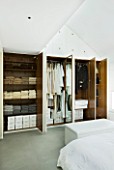 TANIA LAURIE  LONDON. WARDROBE SHOWING TANIAS LATEST COLLECTION OF CLOTHING IN BEDROOM