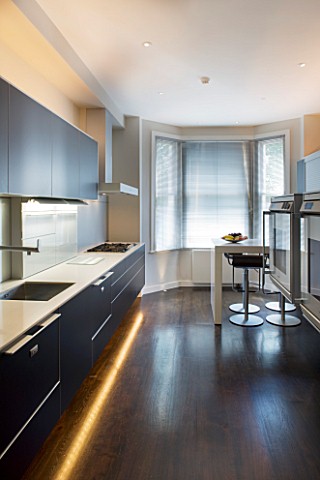 TANIA_LAURIE__LONDON_CONTEMPORARY_KITCHEN_WITH_LIGHTING__BLACK_UNITS__WOODEN_FLOOR_AND_BREAKFAST_BAR