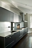 TANIA LAURIE  LONDON. CONTEMPORARY KITCHEN WITH BLACK UNITS AND COMPOSITE WORKTOP