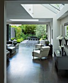 TANIA LAURIE  LONDON. INTERIOR OF LIVING / DINING AREA LEADING OUT ONTO PATIO AND CONTEMPORARY GARDEN DESIGNED BY CHARLOTTE ROWE
