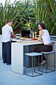 CONTEMPORARY FORMAL ROOF TERRACE/ GARDEN DESIGNED BY DATA NATURE ASSOCIATES: NICK LEITH-SMITH AND KRISTINA HULSEBUS HAVING A BARBEQUE