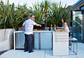 CONTEMPORARY FORMAL ROOF TERRACE/ GARDEN DESIGNED BY DATA NATURE ASSOCIATES: NICK LEITH-SMITH AND KRISTINA HULSEBUS HAVING A BARBEQUE