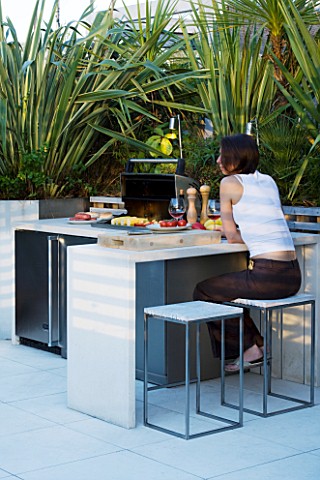 CONTEMPORARY_FORMAL_ROOF_TERRACE_GARDEN_DESIGNED_BY_DATA_NATURE_ASSOCIATES_GIRL_SITTING_AT_A_TABLE_B