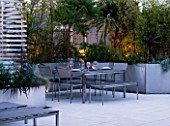 CONTEMPORARY FORMAL ROOF TERRACE/ GARDEN DESIGNED BY DATA NATURE ASSOCIATES: SEATING AREA AT NIGHT WITH LIGHTING. TABLE  CHAIRS  TRELLIS AND RAISED BEDS