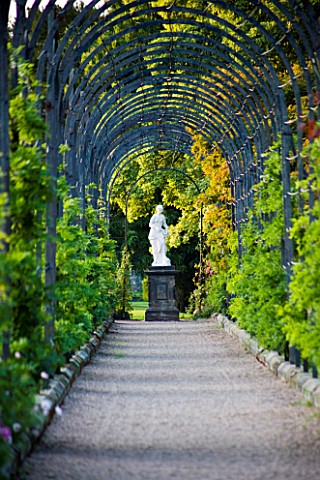 TRENTHAM_GARDENS__STAFFORDSHIRE_VIEW_ALONG_METAL_ARBOUR_TO_STATUE_IN_EVENING_LIGHT