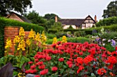 WOLLERTON OLD HALL  SHROPSHIRE: VIEW UPTO THE HOUSE WITH MONARDA GARDENVIEW SCARLET AND LIGULARIA GREGYNOG GOLD