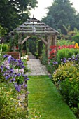 WOLLERTON OLD HALL  SHROPSHIRE: VIEW FROM ALICES GARDEN WITH DAISY BORDERS TOWARDS OAK GAZEBO WITH PHLOX PANICULATA BLUE PARADISE