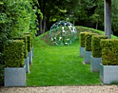 DAVID HARBER SUNDIALS: CLIPPED BOX IN METAL CONTAINERS AND THE NUAGE SCULPTURE ON LAWN. FORMAL GARDEN SETTING.