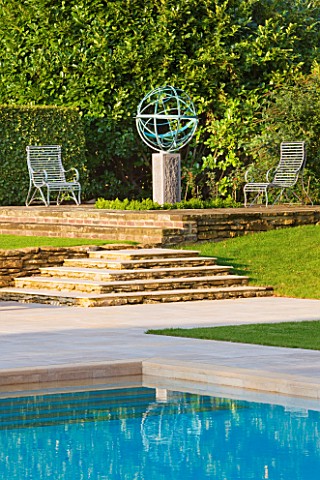 DAVID_HARBER_SUNDIALS_ARMILLARY_SPHERE_SUNDIAL_AND_SWIMMING_POOL_WITH_STONE_STEPS_AND_METAL_CHAIRS