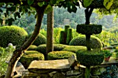 PROVENCE  FRANCE: GARDEN OF NICOLE DE VESIAN  LA LOUVE: GRAVEL TERRACE BESIDE THE HOUSE AT DAWN WITH CLIPPED TOPIARY SHAPES AND VIEW OUT ONTO COUNTRYSIDE (GARRIGUE) BEYOND