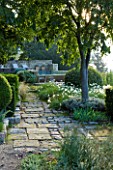 PROVENCE  FRANCE: GARDEN OF NICOLE DE VESIAN  LA LOUVE: SWIMMING POOL AT DAWN ON THE LOWER TERRACE WITH STONE PATH AND CLIPPED SHAPES AND COUNTRYSIDE (GARRIGUE) BEYOND