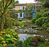 GARDEN OF ERIK BORJA  FRANCE: JAPANESE/ ASIAN STYLE - VIEW TO THE EAST SIDE OF THE HOUSE WITH POOL/POND  WATERLILIES  CLIPPED PINE