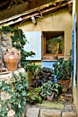 GARDEN OF ERIK BORJA  FRANCE: JAPANESE/ ASIAN STYLE - VIEW OF THE KITCHEN WINDOW WITH CONTAINERS PLANTED WITH BEGONIAS