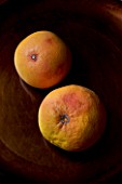 ORGANIC PINK GRAPEFRUIT ON BROWN BACKGROUND. VEGETABLE  HEALTHY EATING  HEALTHY LIVING  CITRUS X PARADISI CONNOTES