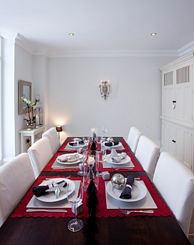 WHITE_DINING_ROOM_WITH_DINING_TABLE__WHITE_CHAIRS__LAID_UP_FOR_CHRISTMAS_SARAH_EASTEL_LOCATIONS_DI_A