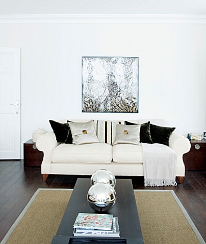 CHRISTMAS__LIVING_ROOM_WITH_WOODEN_COFFEE_TABLE__SILVER_GLOBES__CREAM_SOFA__CUSHIONS_AND_WALL_PRINT_