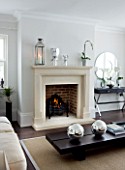 CHRISTMAS - LIVING ROOM WITH CREAM FIREPLACE  CREAM SOFA  WOODEN COFFEE TABLE  SILVER GLOBES  MIRROR. SARAH EASTEL LOCATIONS/ DI ABLEWHITE