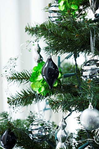 CHRISTMAS__DETAIL_OF_CHRISTMAS_TREE_WITH_BAUBLES_AND_DECORATIONS_SARAH_EASTEL_LOCATIONS_DI_ABLEWHITE